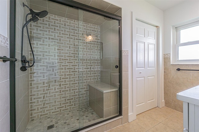 5950 Bikini Way N, St Pete Beach, FL 33706 - full bath featuring tile patterned flooring, a shower stall, tile walls, vanity, and a wainscoted wall