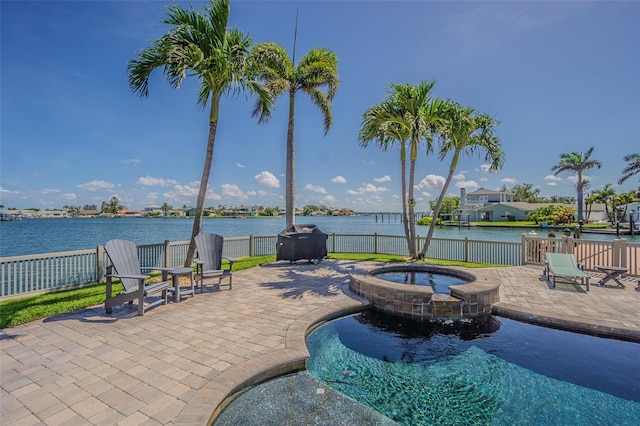 5950 Bikini Way N, St Pete Beach, FL 33706 - view of swimming pool with a patio area, a pool with connected hot tub, a fenced backyard, and a water view