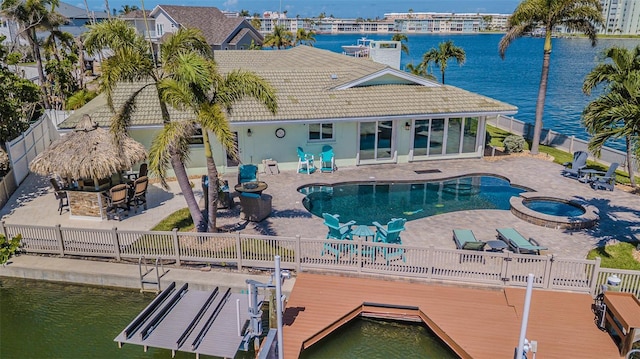 5950 Bikini Way N, St Pete Beach, FL 33706 - back of property featuring a tile roof, a fenced backyard, stucco siding, a patio, and a pool with connected hot tub