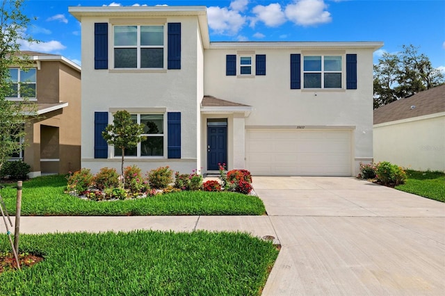 33657 Field Maple Loop, Wesley Chapel, FL 33545 - view of front facade with stucco siding, a garage, and driveway