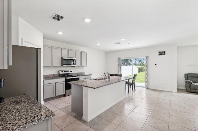33657 Field Maple Loop, Wesley Chapel, FL 33545 - kitchen featuring appliances with stainless steel finishes, gray cabinets, dark stone countertops, open floor plan, and recessed lighting