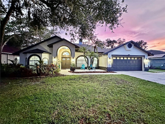 4617 Basswood St, Land O Lakes, FL 34639 - ranch-style house with stucco siding, an attached garage, concrete driveway, and a front lawn