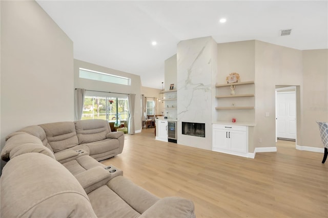 4617 Basswood St, Land O Lakes, FL 34639 - living room with high vaulted ceiling, light wood-style floors, a premium fireplace, beverage cooler, and recessed lighting