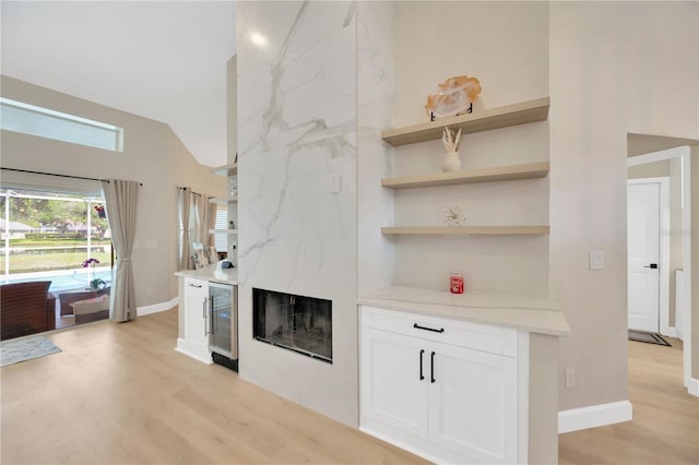 4617 Basswood St, Land O Lakes, FL 34639 - unfurnished living room with wine cooler, light wood finished floors, vaulted ceiling, and a fireplace