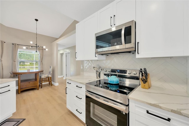 4617 Basswood St, Land O Lakes, FL 34639 - kitchen with appliances with stainless steel finishes, lofted ceiling, tasteful backsplash, white cabinets, and light wood finished floors