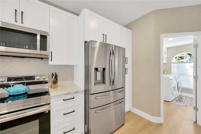 4617 Basswood St, Land O Lakes, FL 34639 - kitchen featuring appliances with stainless steel finishes, light wood-style floors, tasteful backsplash, and white cabinets