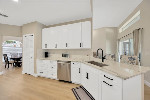 4617 Basswood St, Land O Lakes, FL 34639 - kitchen with stainless steel dishwasher, a peninsula, light wood finished floors, and light stone counters