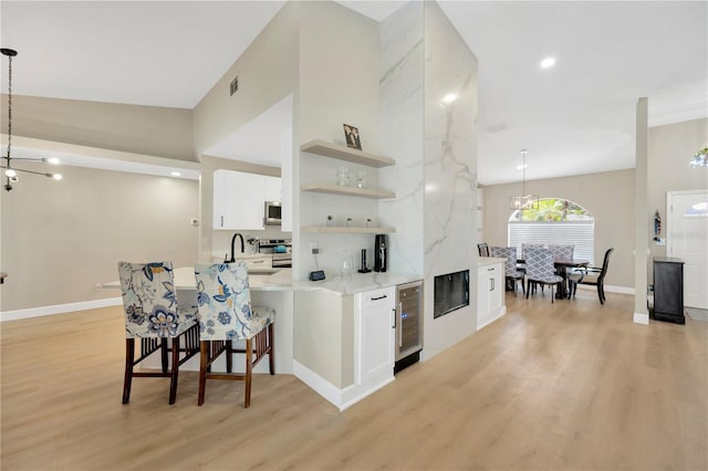 4617 Basswood St, Land O Lakes, FL 34639 - kitchen with light wood-style floors, open shelves, white cabinets, a breakfast bar, and recessed lighting