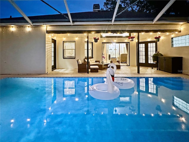 4617 Basswood St, Land O Lakes, FL 34639 - pool at night featuring french doors, an outdoor pool, and a patio area
