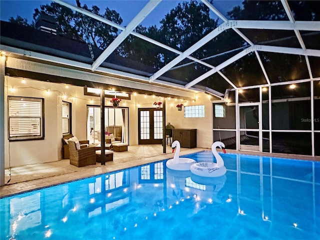 4617 Basswood St, Land O Lakes, FL 34639 - pool at night featuring french doors, an outdoor pool, a patio area, and an outdoor living space