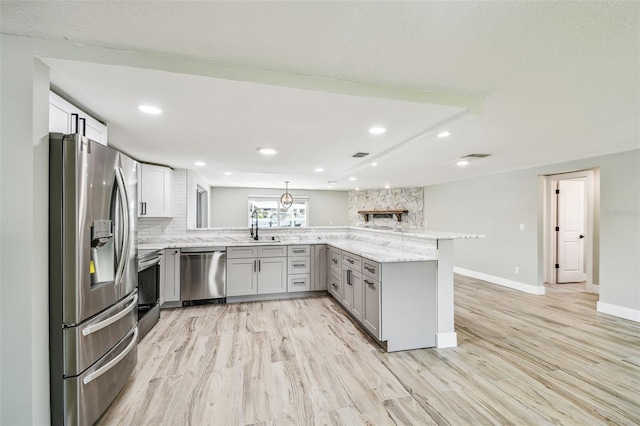 13909 Berkowitz Ave, Hudson, FL 34667 - kitchen featuring appliances with stainless steel finishes, a peninsula, gray cabinets, backsplash, and recessed lighting