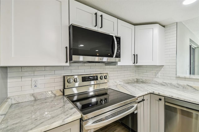 13909 Berkowitz Ave, Hudson, FL 34667 - kitchen with appliances with stainless steel finishes, decorative backsplash, white cabinets, and light stone countertops