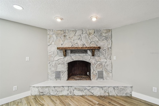 13909 Berkowitz Ave, Hudson, FL 34667 - detailed view of wood finished floors, a textured ceiling, and a stone fireplace
