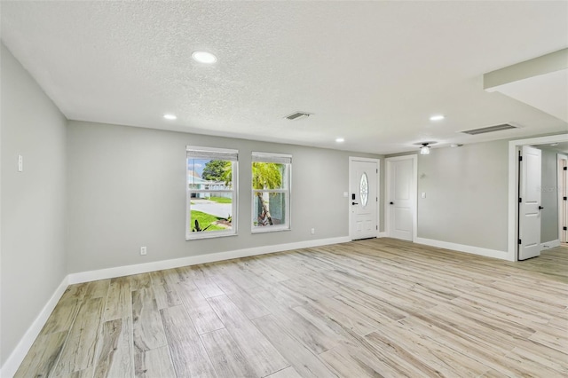 13909 Berkowitz Ave, Hudson, FL 34667 - entrance foyer featuring light wood finished floors, recessed lighting, and a textured ceiling