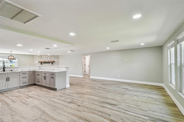 13909 Berkowitz Ave, Hudson, FL 34667 - kitchen featuring gray cabinets, plenty of natural light, light wood-style floors, and recessed lighting