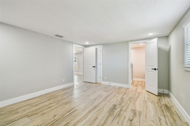 13909 Berkowitz Ave, Hudson, FL 34667 - spare room featuring light wood finished floors, recessed lighting, and a textured ceiling