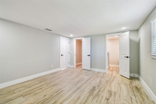 13909 Berkowitz Ave, Hudson, FL 34667 - unfurnished bedroom featuring light wood-style flooring, recessed lighting, and a textured ceiling