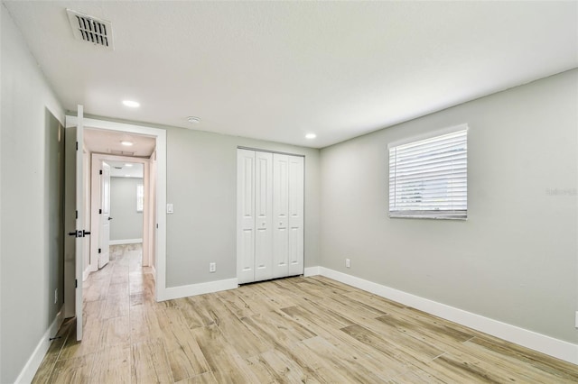 13909 Berkowitz Ave, Hudson, FL 34667 - unfurnished bedroom featuring light wood-type flooring, a closet, and recessed lighting