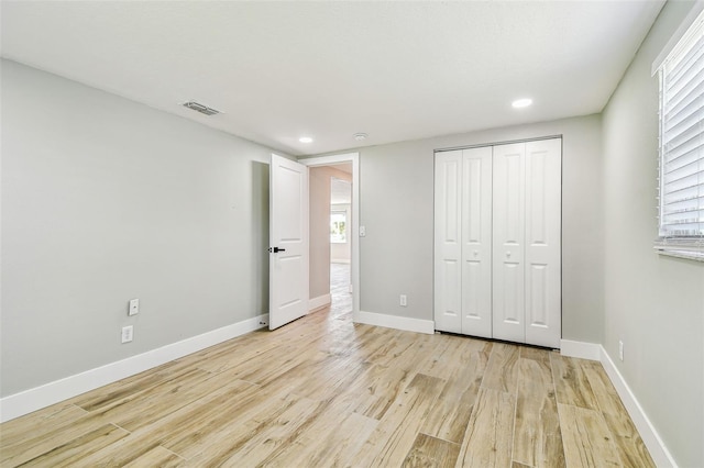 13909 Berkowitz Ave, Hudson, FL 34667 - unfurnished bedroom featuring light wood finished floors, recessed lighting, a closet, and multiple windows