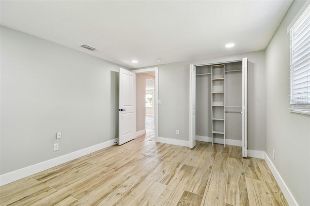13909 Berkowitz Ave, Hudson, FL 34667 - unfurnished bedroom featuring light wood-style flooring, recessed lighting, a closet, and multiple windows