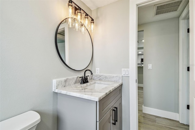 13909 Berkowitz Ave, Hudson, FL 34667 - half bath featuring vanity, wood finished floors, and a chandelier