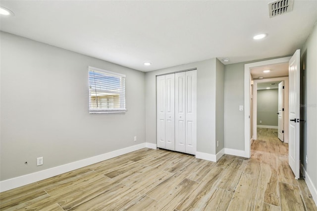 13909 Berkowitz Ave, Hudson, FL 34667 - unfurnished bedroom with light wood finished floors, recessed lighting, and a closet