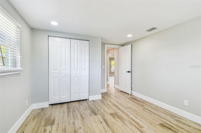 13909 Berkowitz Ave, Hudson, FL 34667 - unfurnished bedroom featuring light wood-style flooring, a closet, and recessed lighting