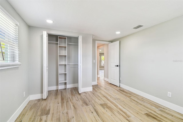 13909 Berkowitz Ave, Hudson, FL 34667 - unfurnished bedroom featuring light wood finished floors, a closet, and recessed lighting