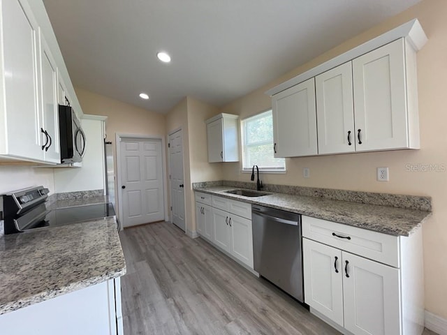 16910 SW 27th Ave, Ocala, FL 34473 - kitchen with stainless steel appliances, light wood-style floors, lofted ceiling, white cabinets, and recessed lighting