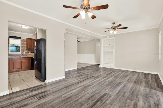 10375 106th Ter, Largo, FL 33773 - unfurnished living room with ceiling fan, ornamental molding, light wood-type flooring, and built in features