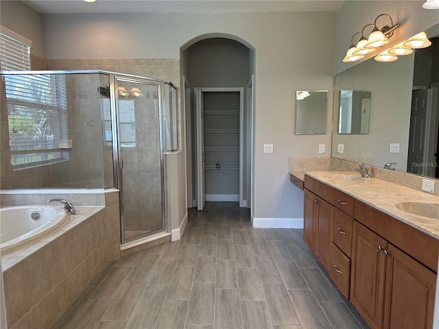 1008 Arista Blvd, Valrico, FL 33594 - full bathroom featuring a bath, double vanity, a stall shower, and a spacious closet