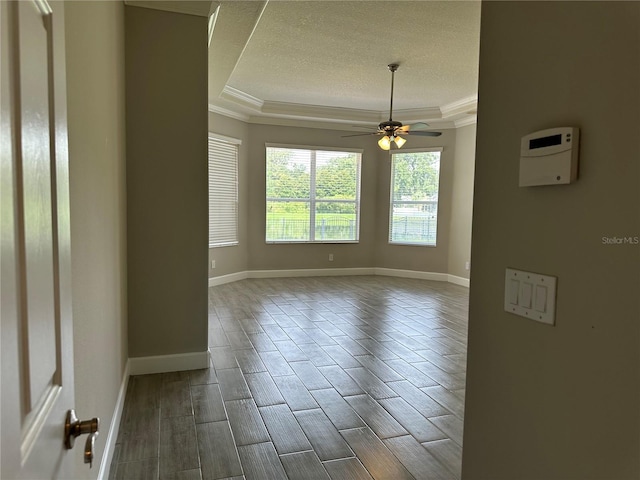 1008 Arista Blvd, Valrico, FL 33594 - empty room featuring a tray ceiling, ornamental molding, a textured ceiling, a ceiling fan, and wood tiled floors
