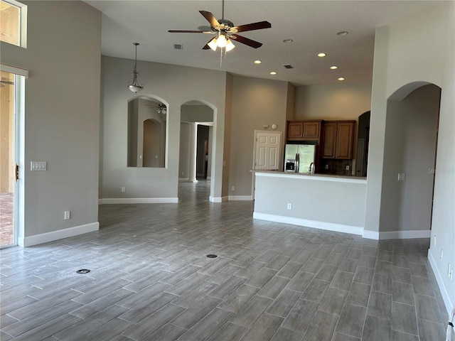 1008 Arista Blvd, Valrico, FL 33594 - unfurnished living room with arched walkways, a ceiling fan, wood finished floors, and recessed lighting