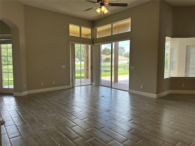 1008 Arista Blvd, Valrico, FL 33594 - unfurnished room with arched walkways, a ceiling fan, dark wood-style floors, healthy amount of natural light, and a towering ceiling