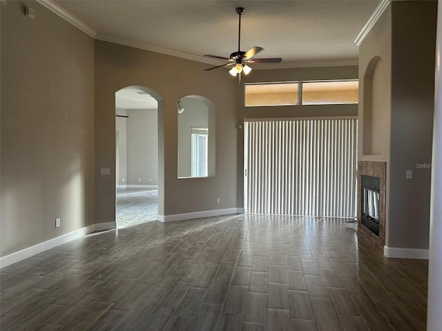 1008 Arista Blvd, Valrico, FL 33594 - unfurnished room featuring a ceiling fan, arched walkways, ornamental molding, dark wood-type flooring, and a tiled fireplace