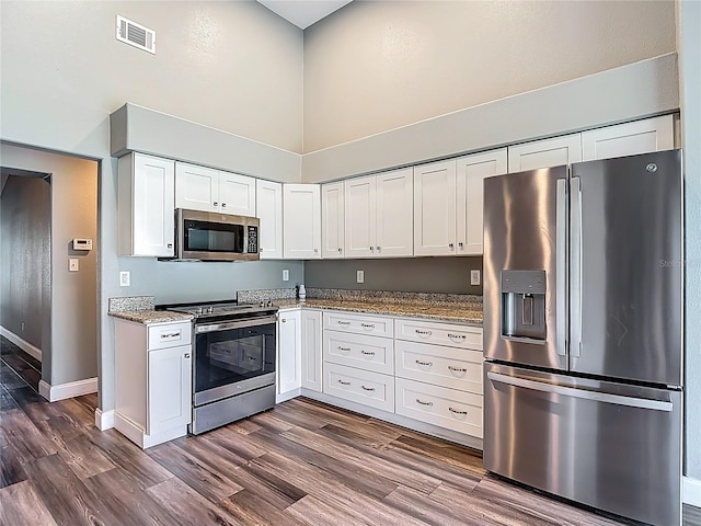 10206 Evening Trail Dr, Riverview, FL 33569 - kitchen with appliances with stainless steel finishes, a high ceiling, white cabinets, and dark wood-style flooring