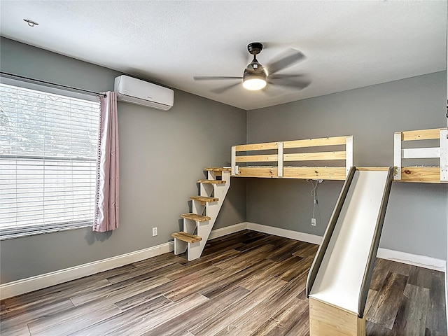 10206 Evening Trail Dr, Riverview, FL 33569 - unfurnished bedroom with an AC wall unit, multiple windows, wood finished floors, and a ceiling fan