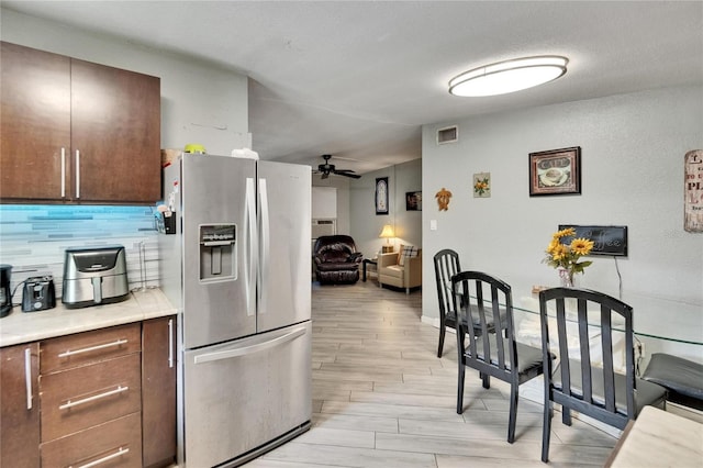 10549 112th Ave, Largo, FL 33773 - kitchen with stainless steel fridge, light wood finished floors, ceiling fan, decorative backsplash, and light countertops