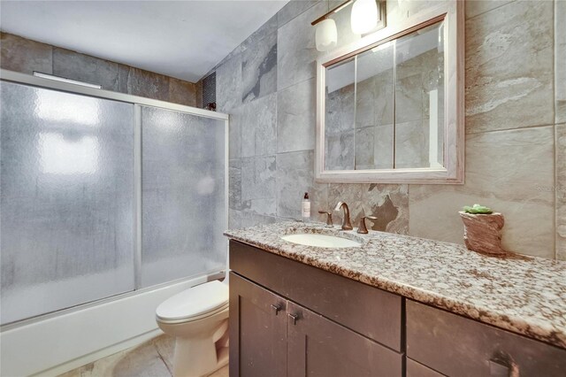 10549 112th Ave, Largo, FL 33773 - bathroom with tile walls, vanity, and bath / shower combo with glass door