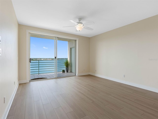 7979 Sailboat Key Blvd S Unit 505, South Pasadena, FL 33707 - spare room featuring light wood-style flooring, a ceiling fan, and a water view
