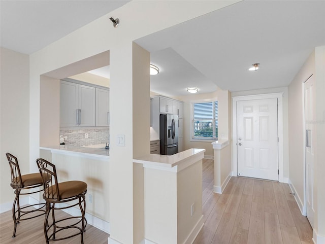 7979 Sailboat Key Blvd S Unit 505, South Pasadena, FL 33707 - kitchen with stainless steel refrigerator with ice dispenser, light wood-type flooring, light countertops, and a peninsula