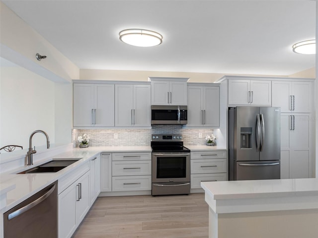 7979 Sailboat Key Blvd S Unit 505, South Pasadena, FL 33707 - kitchen featuring stainless steel appliances, backsplash, light wood-type flooring, and light stone counters
