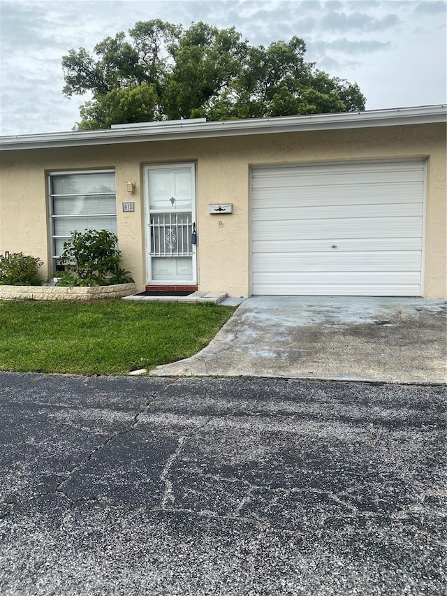 832 Cambridge Ct, Dunedin, FL 34698 - view of front of house featuring concrete driveway, stucco siding, and an attached garage