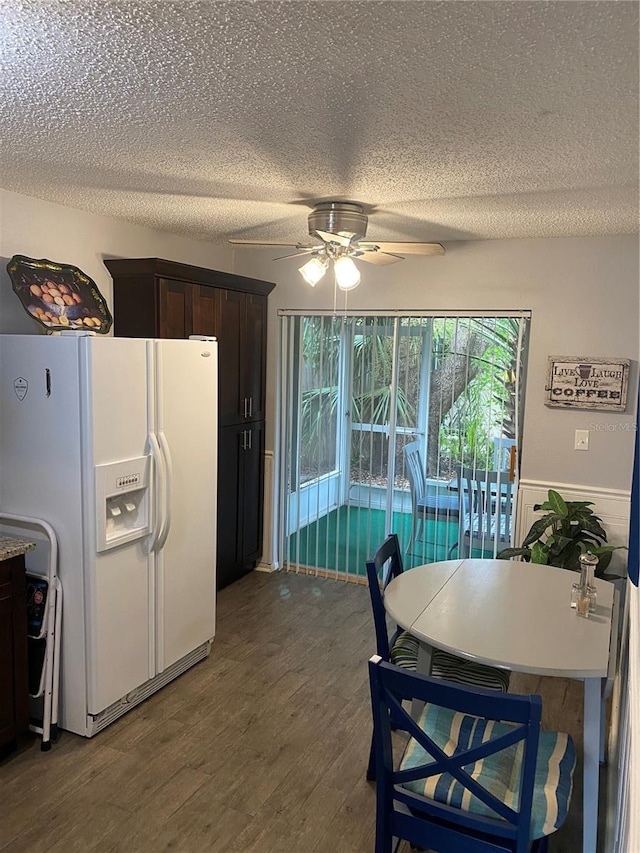 832 Cambridge Ct, Dunedin, FL 34698 - kitchen featuring white fridge with ice dispenser, a textured ceiling, a ceiling fan, wood finished floors, and dark brown cabinets