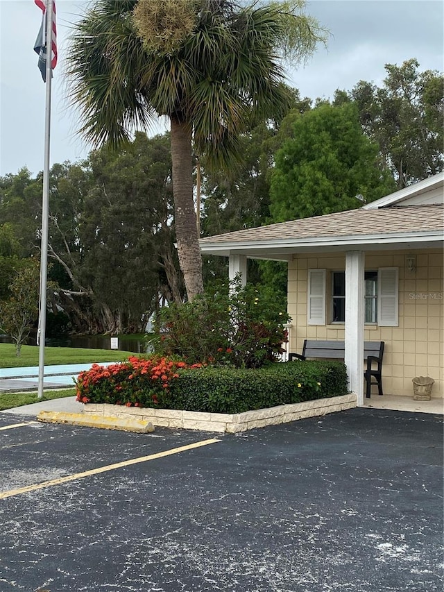 832 Cambridge Ct, Dunedin, FL 34698 - view of property exterior with roof with shingles and uncovered parking