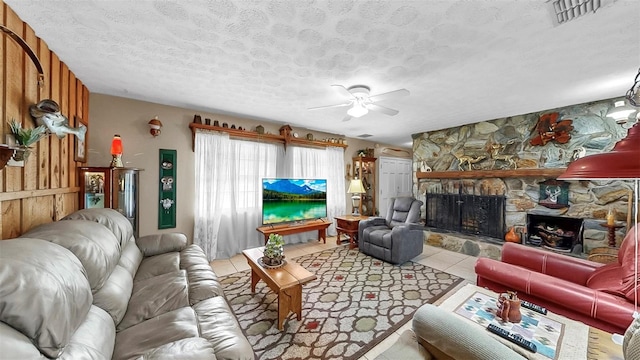 1753 Ranchette Rd, Wesley Chapel, FL 33543 - living area featuring a fireplace, ceiling fan, a textured ceiling, and tile patterned flooring