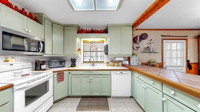 1753 Ranchette Rd, Wesley Chapel, FL 33543 - kitchen with white appliances, green cabinets, wallpapered walls, tile counters, and light tile patterned floors