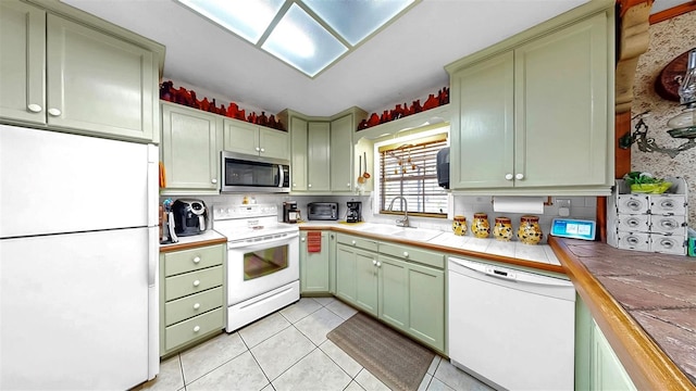 1753 Ranchette Rd, Wesley Chapel, FL 33543 - kitchen with white appliances, green cabinets, tile counters, decorative backsplash, and light tile patterned flooring