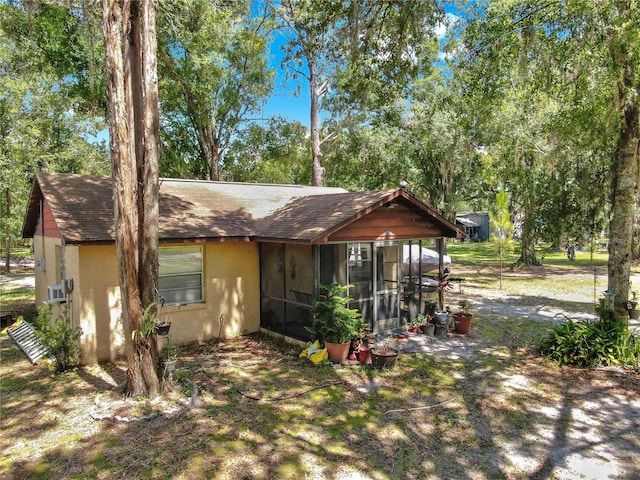1753 Ranchette Rd, Wesley Chapel, FL 33543 - view of front of house with a sunroom, stucco siding, and roof with shingles