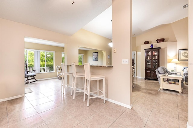 1626 Terra Ceia Bay Cir Unit 1626, Palmetto, FL 34221 - kitchen with light tile patterned flooring, a breakfast bar, stone countertops, and vaulted ceiling